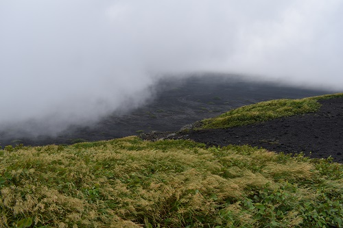 海水浴客でにぎわう海沿いは青空でも、三原山は雲の中。